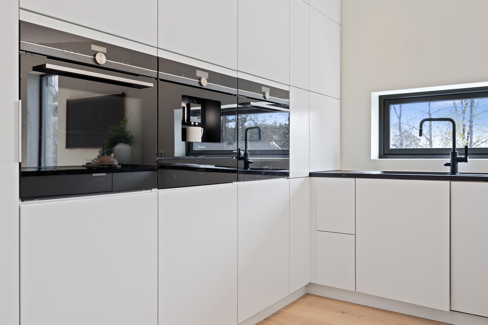 Kjøkkenet har integrerte hvitevarer og stilrent design. Galleribilde