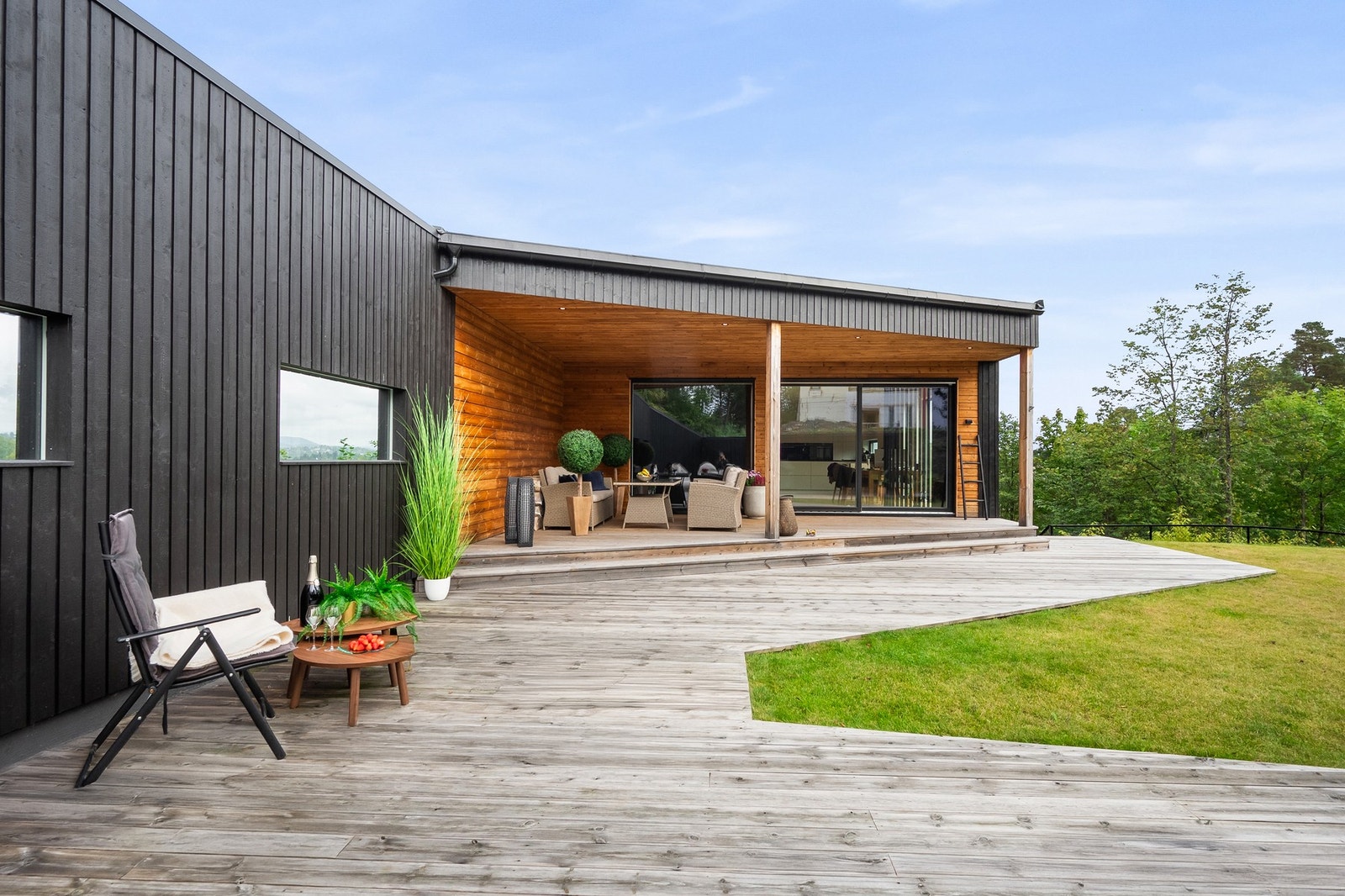 Moderne bolig med stor terrasse, overbygd uteplass og store vindusflater Galleribilde
