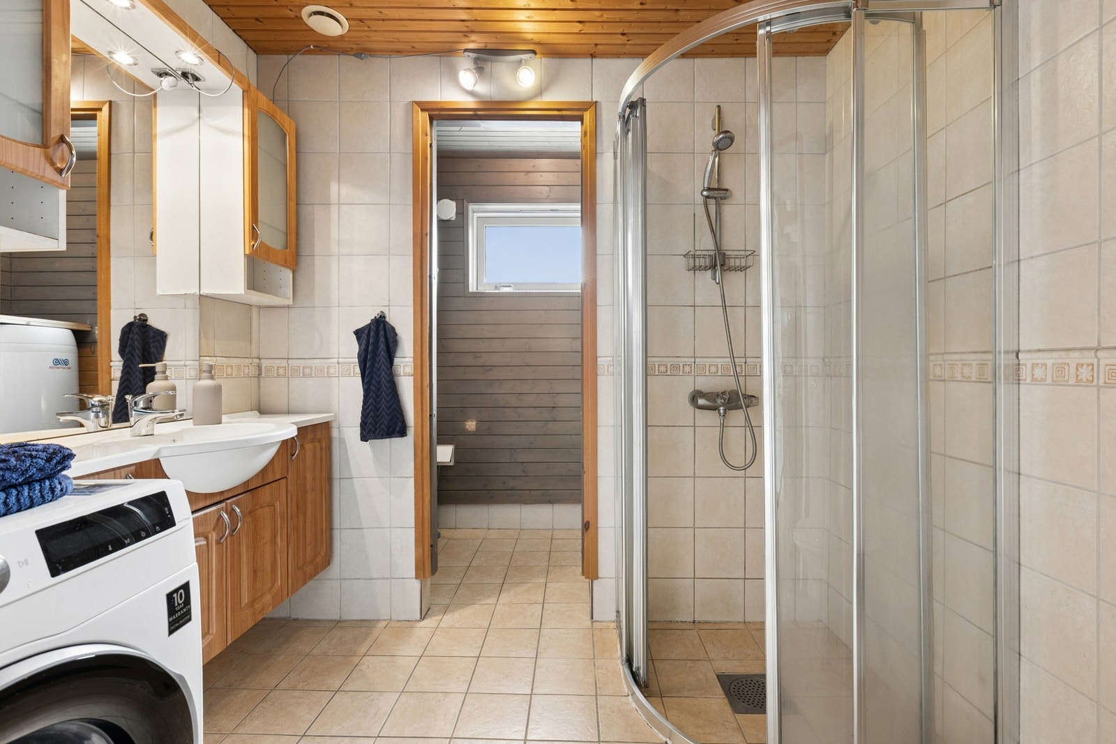 Badet ligger i første etasje og er innredet med dusjhjørne, toalett, servant med innredning, opplegg for vaskemaskin og varmtvannsbereder. Galleribilde