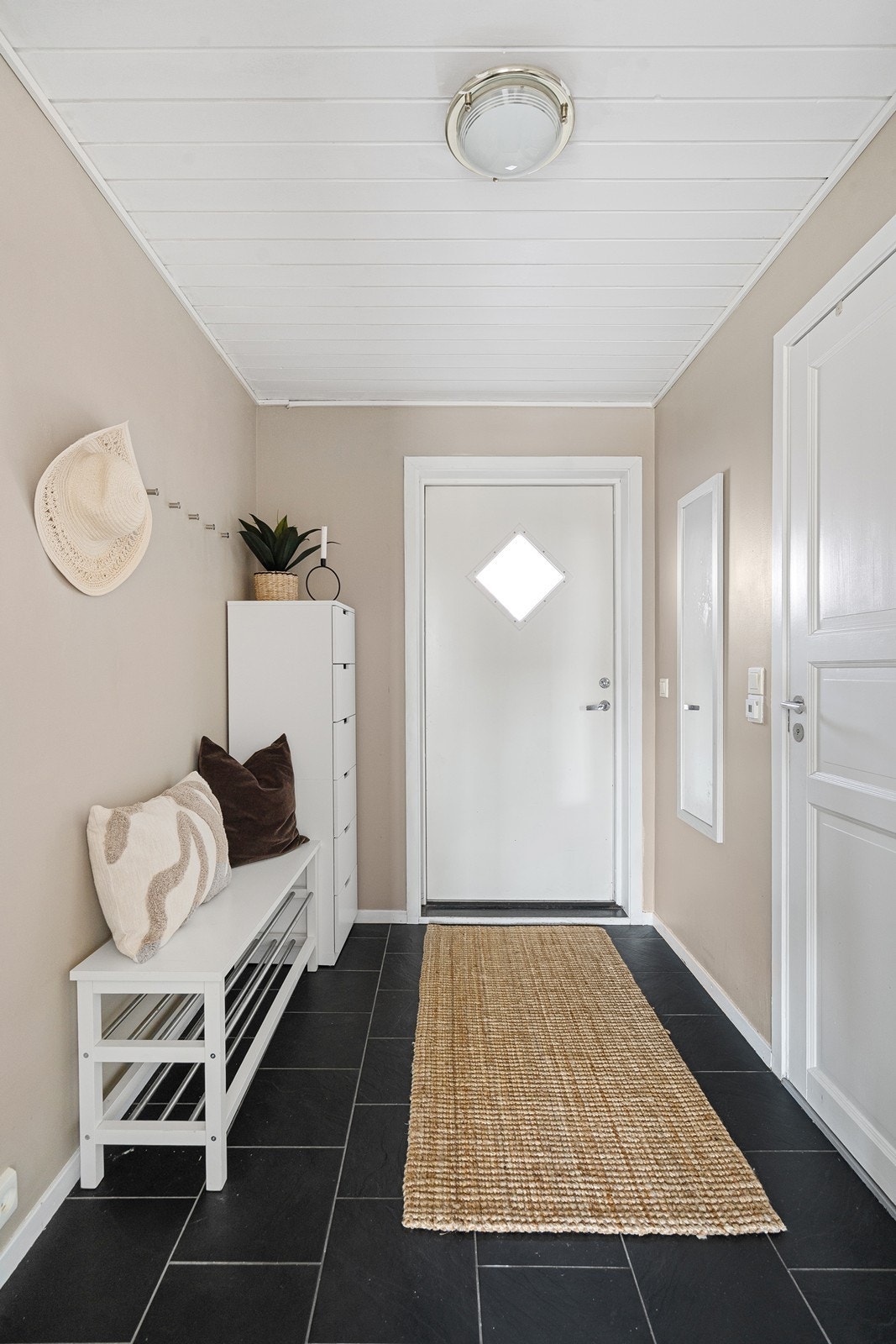 Velkommen inn! Praktisk entré/gang som gir et godt førsteinntrykk og plass til oppbevaring av yttertøy og sko. Galleribilde