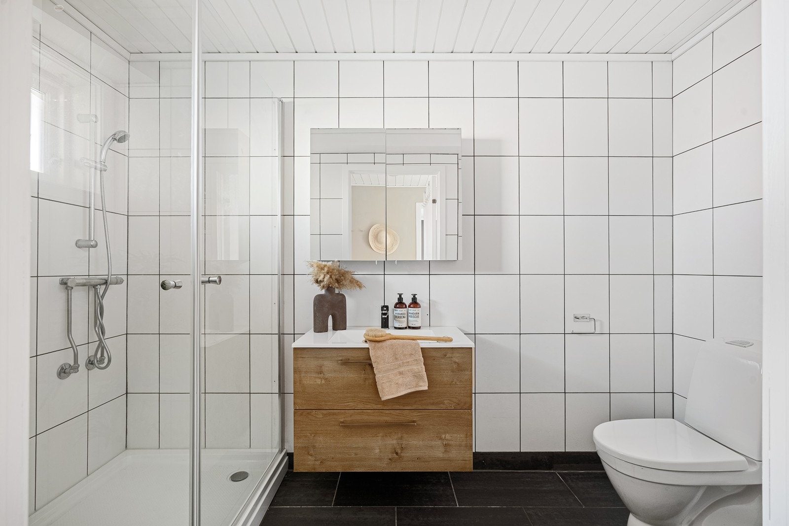 Badet er flislagt på både gulv og vegger, og fremstår praktisk og lettstelt. Galleribilde