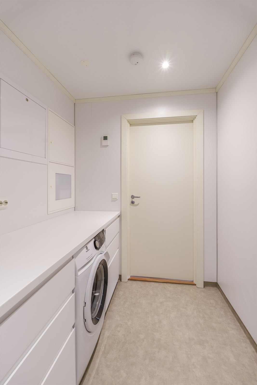 Det er montert et praktisk benkeskap med opplegg for vaskemaskin integrert. Galleribilde