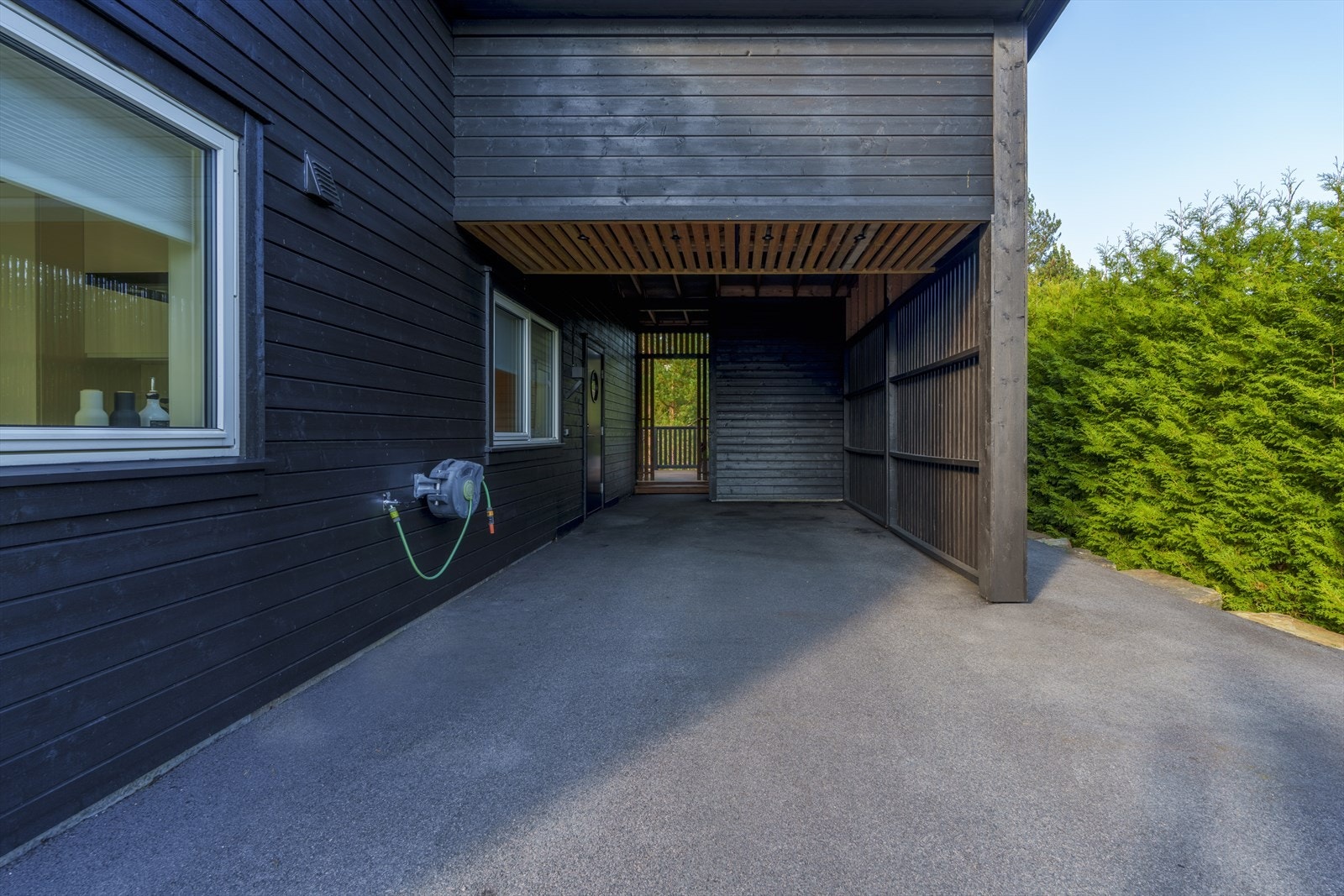 Carporten er en del av gårdsplassen, og har downlights, lagringshems og hendig utebod. Galleribilde