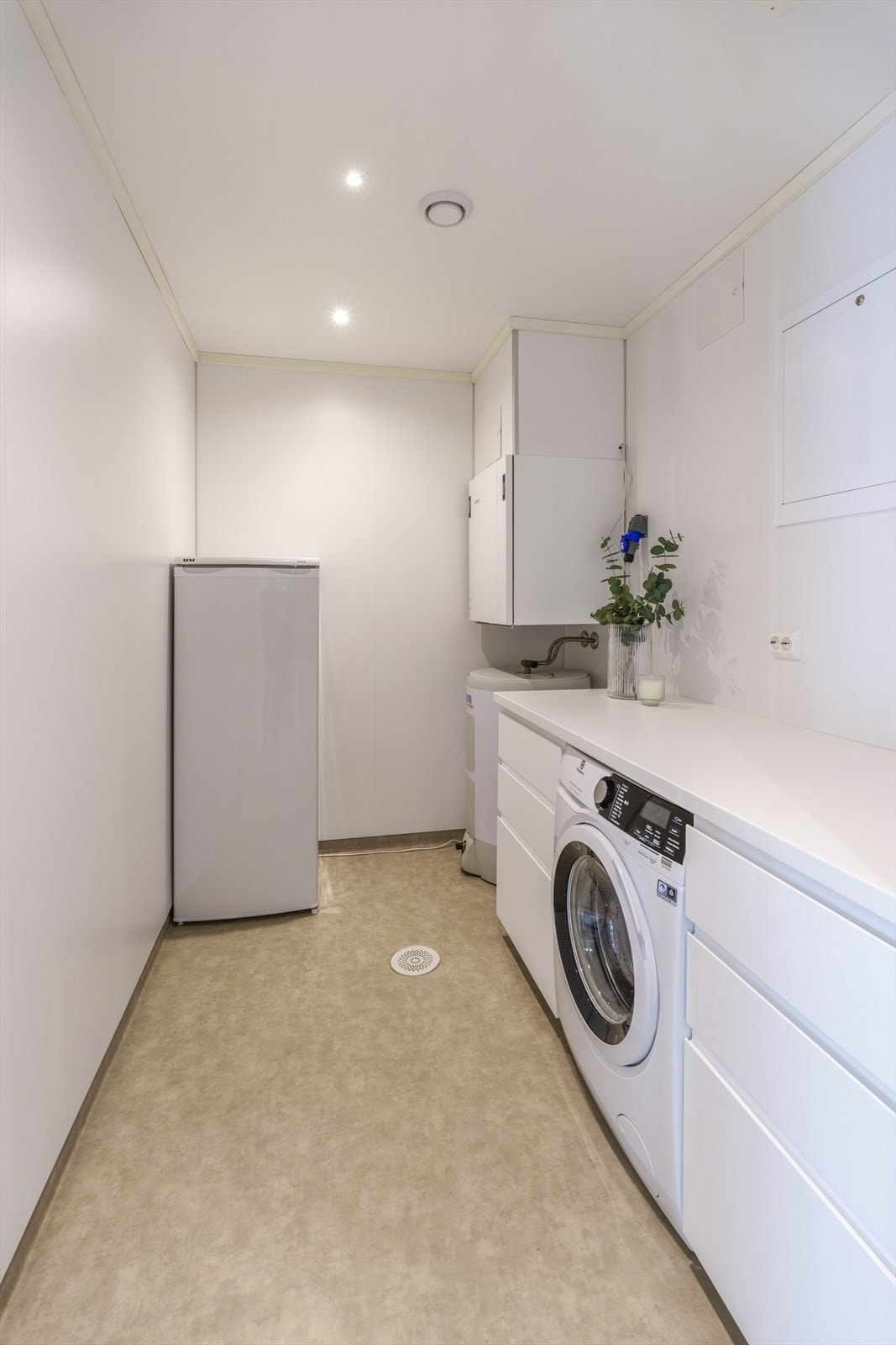 Vegg i vegg med badet har boligen et eget vaskerom for enklere hverdager. Galleribilde