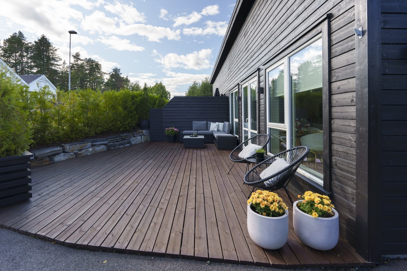 Sammen med en hekk bidrar en levegg mot naboen til fin skjerming på terrassen. Galleribilde