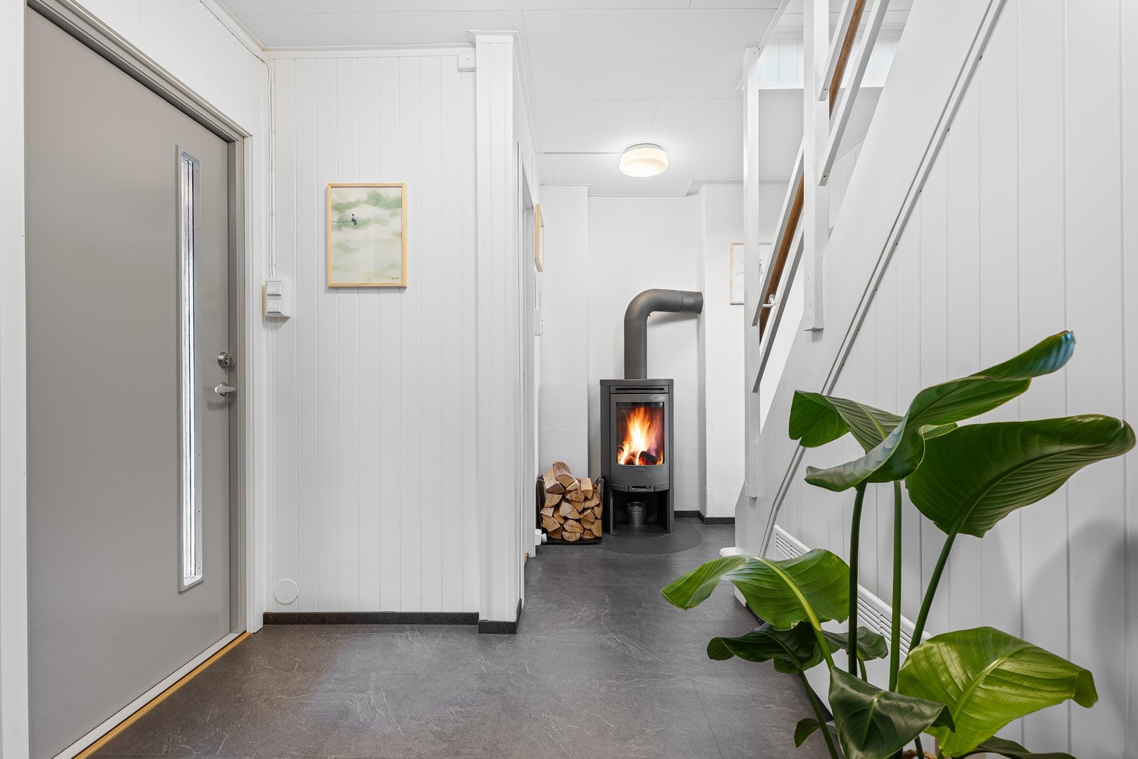 I entréen er det behagelig varme fra en moderne vedovn. Galleribilde