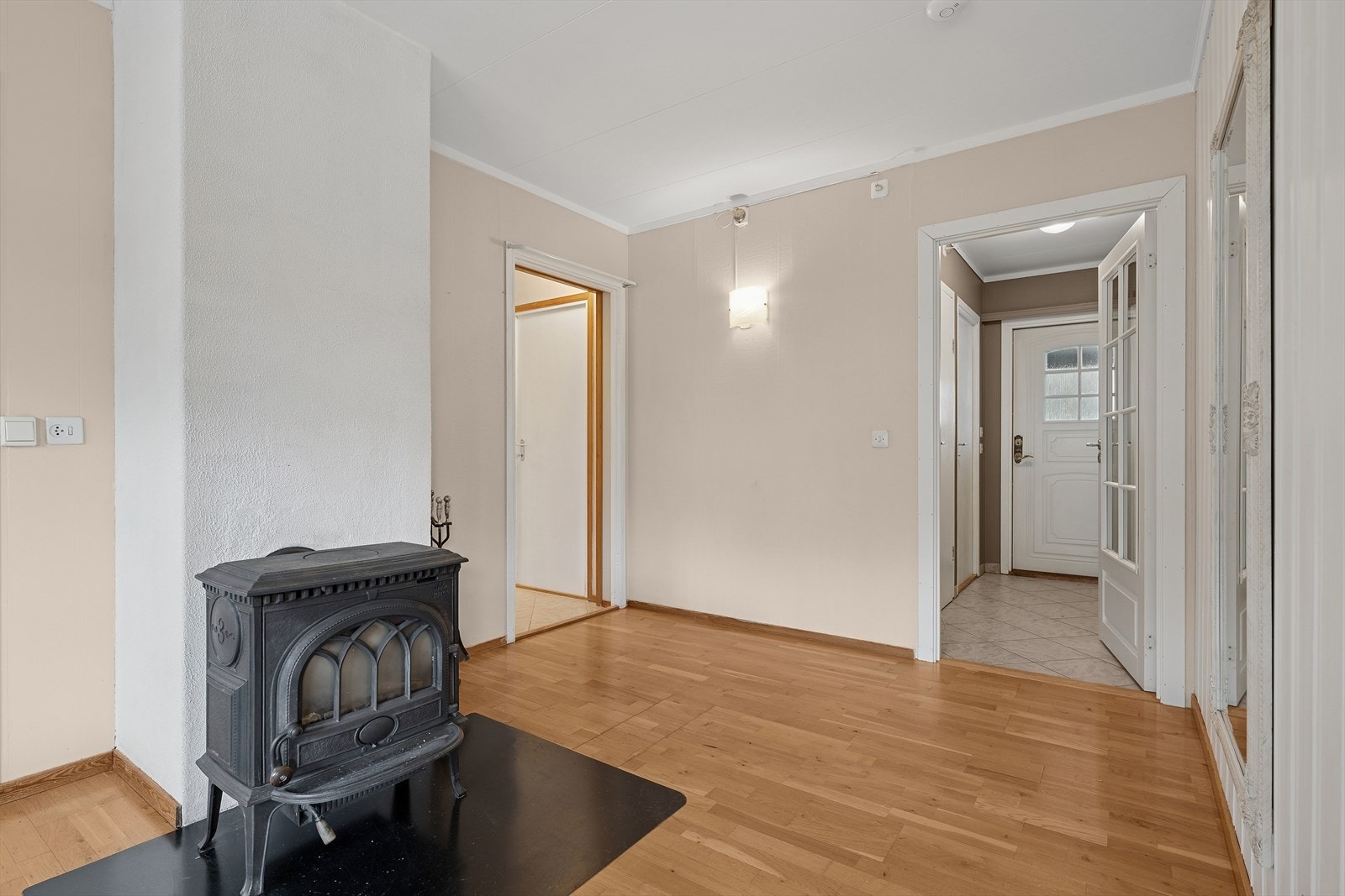 Når du kommer inn i boligen, møtes du først av et praktisk vindfang før du trer inn i en åpen og lys stue. Midt i rommet står en vedovn som gir både varme og en lun atmosfære Galleribilde