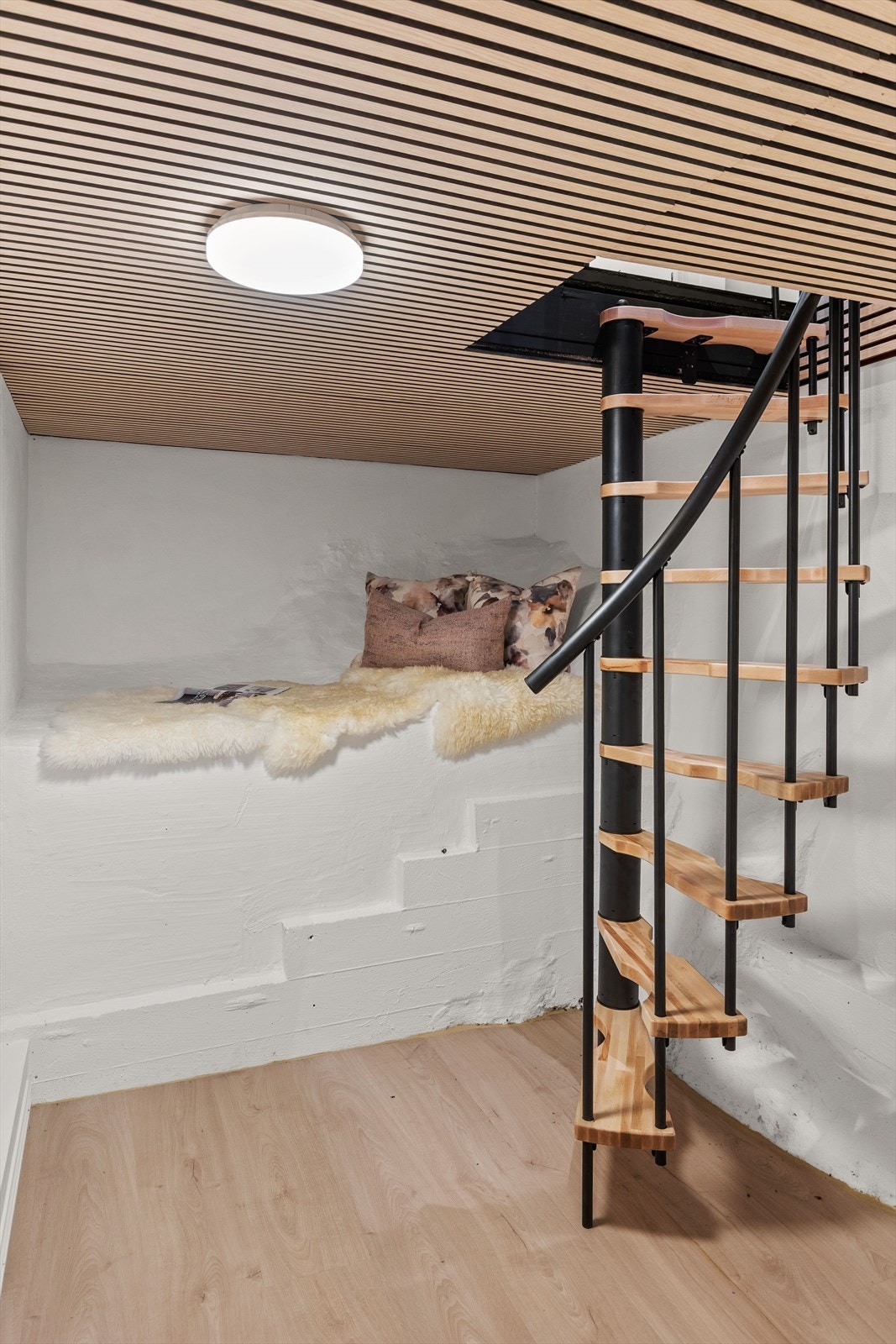 Spiraltrappen fører ned til et innredet rom med spilepanel i himlingen. Takhøyden her er ca. 1,98 meter. Galleribilde