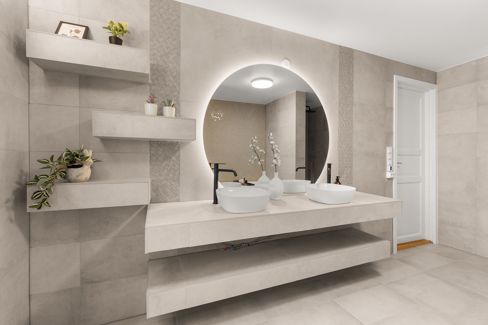 Badet har en plassbygget benkeinnredning med doble servanter og varmekabler i gulvet. Galleribilde