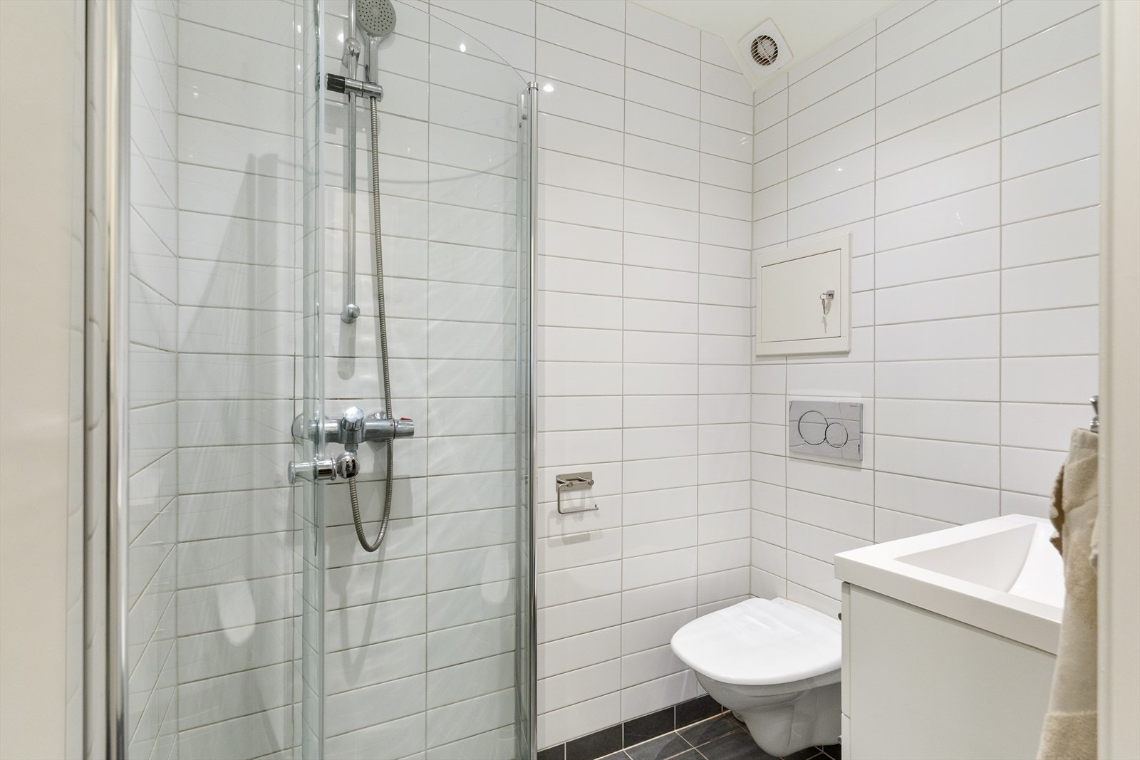Pent, flislagt baderom med innfelt downlights i himling med malte plater. Galleribilde
