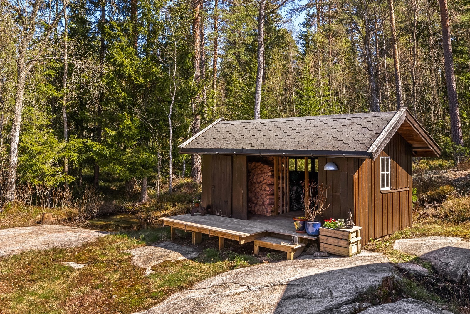 Et overbygget vedskjul/uthus gir ekstra, praktisk lagringsplass. Galleribilde
