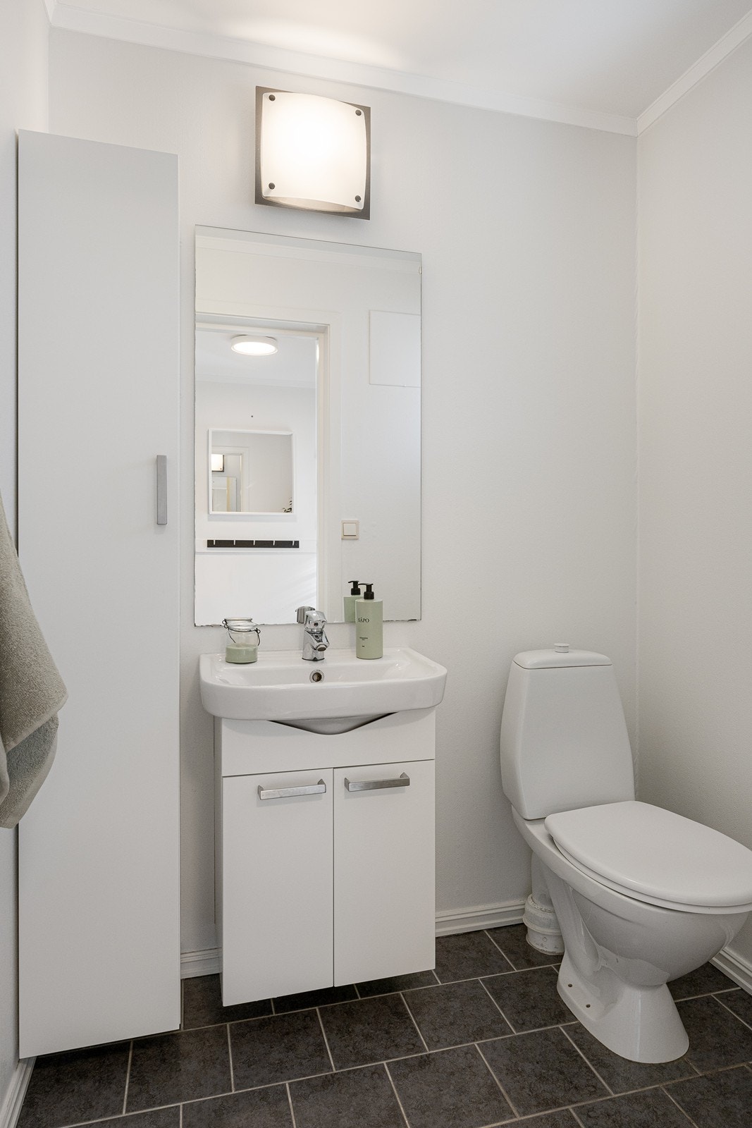 Wc-rommet tilknyttet entréen har gulvmontert toalett, hvit servantseksjon, matchende høyskap og behagelig varme i gulvet. Galleribilde