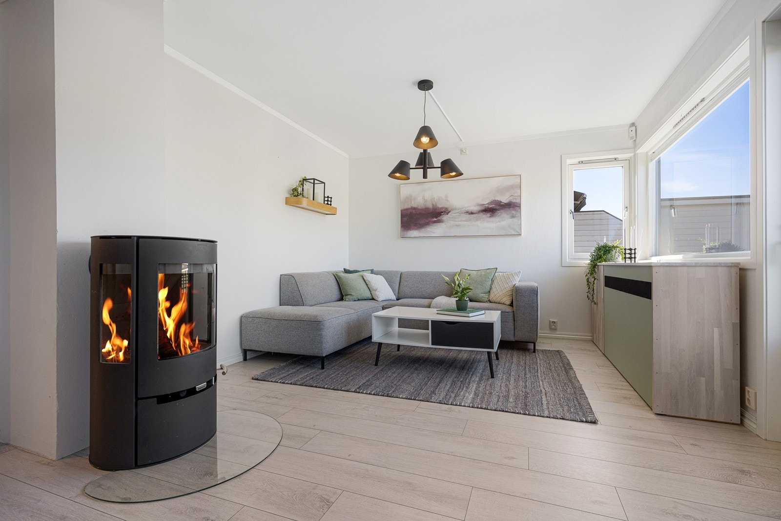 Sentralt i rommet er en moderne og rentbrennende peisovn fra 2022 som bidrar til ekstra hygge og varme. Galleribilde