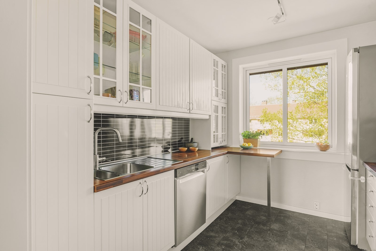 IKEA-kjøkken fra 2009 med hvite fronter. Det er rikelig med skap og benkeplass. Praktisk barløsning for morgenkaffen eller en rask frokost Galleribilde