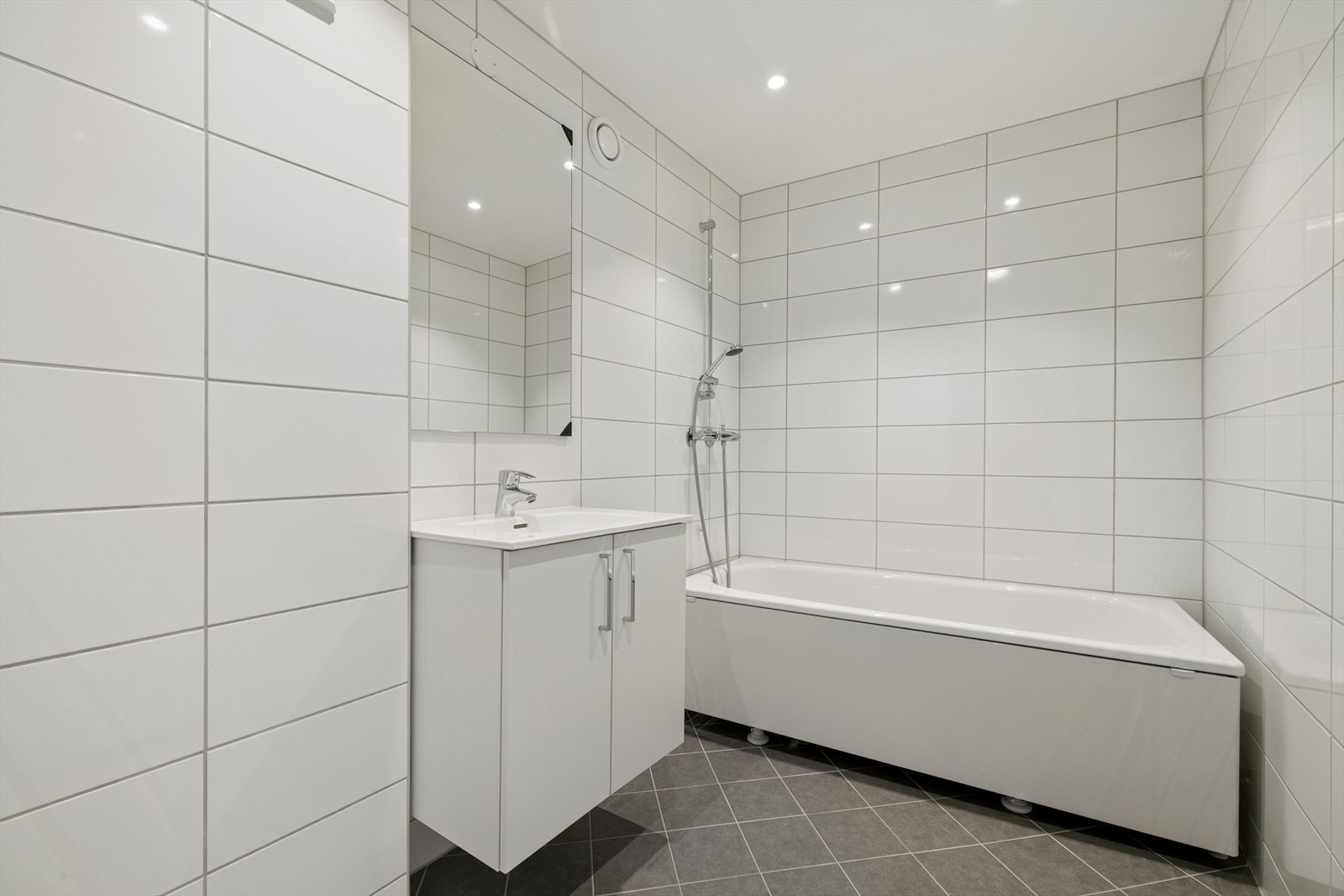 Helfliset bad fra 2023 med innfelte downlights, gulvvarme og badekar. Det er klargjort for vaskemaskin. Galleribilde