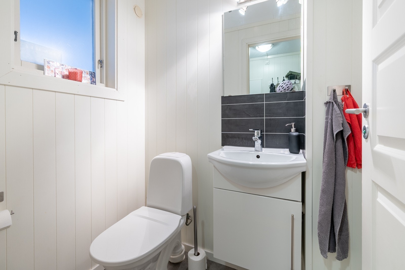 Toalettrom med fliselagt gulv, wc og servantskap Galleribilde