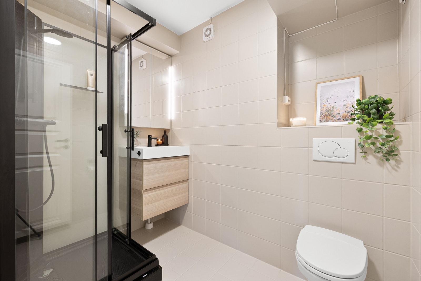 Badet fremstår delikat med flislagte overflater og moderne innredning. Galleribilde