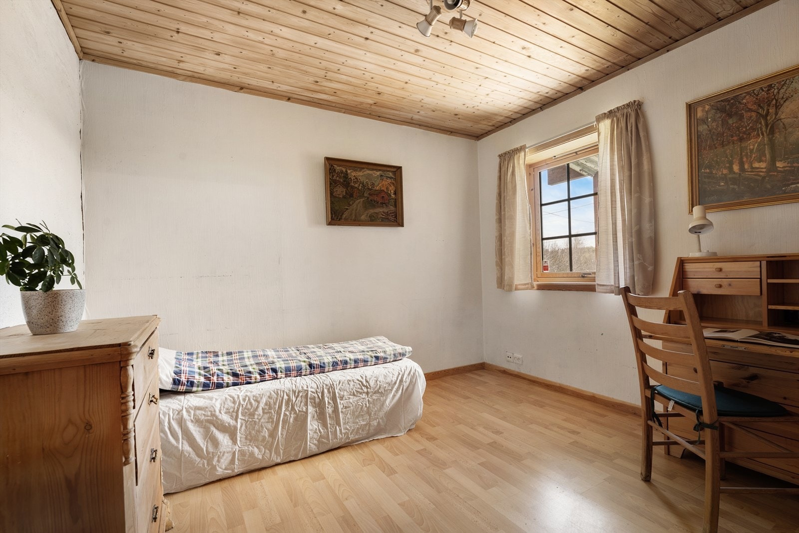Soverom i underetasjen med panel i taket og laminat på gulvet. Galleribilde