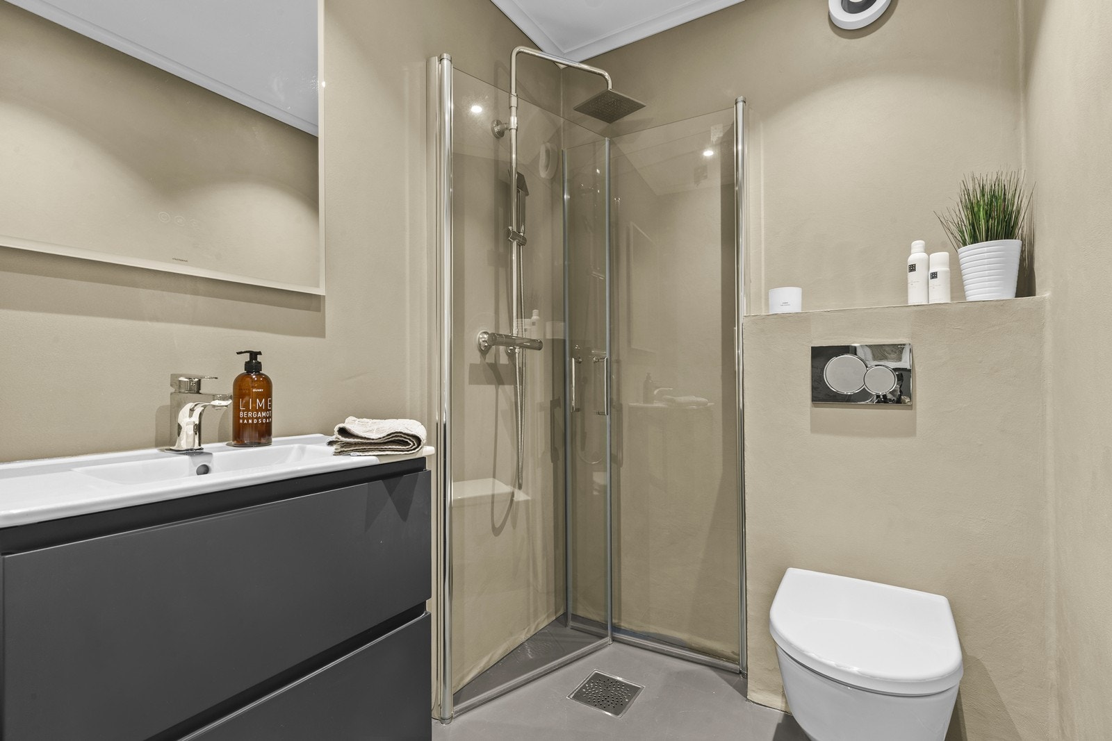 Badet har moderne overflater med mikrosement på gulv og vegger samt en dusjsone med glassvegger. Galleribilde