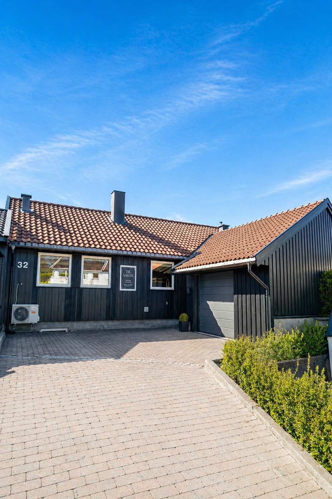 Innkjørselen består av flotte belegningsstein! Garasje og plass til parkering på tomt. Elbillader er montert på husveggen. Galleribilde