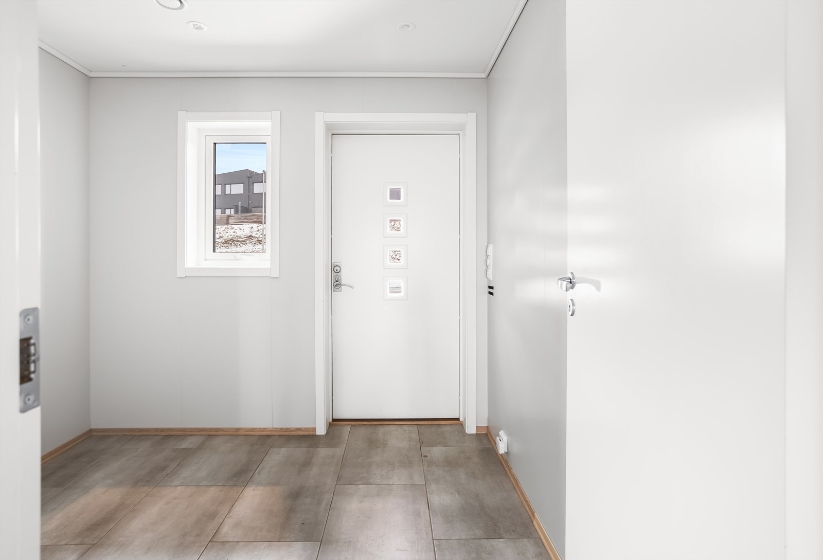 Inngangspartiet har flislagt gulv og gir et praktisk første møte med boligen. Galleribilde