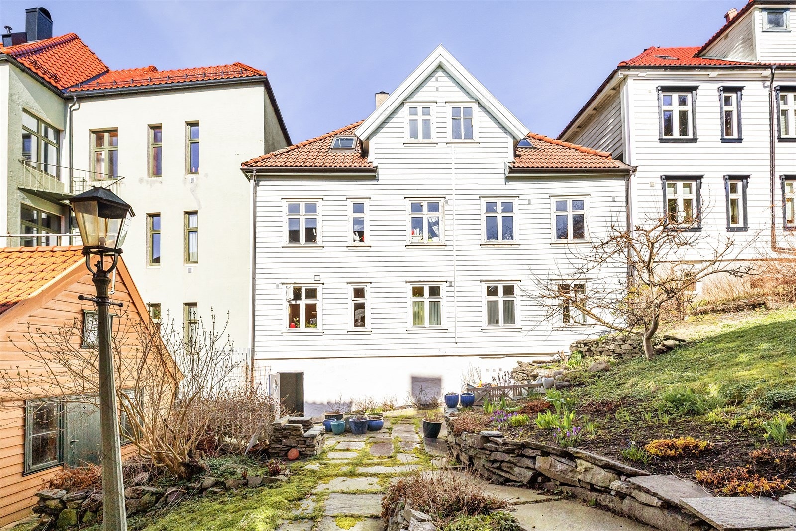 Blant historisk trehusbebyggelse med smau på ene siden og lyst, åpent grøntareal mot Skolemuseet på andre siden. Sameiet har her tilgang til en fin uteplass med beplantning og sittegruppe. Galleribilde