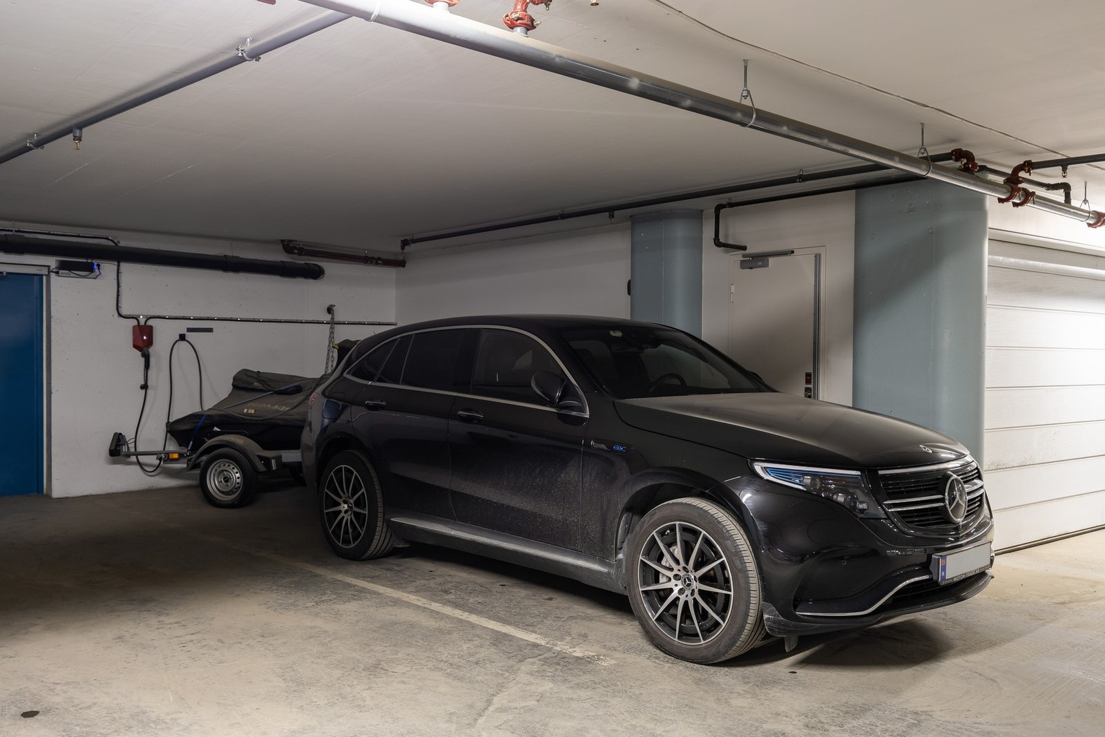 Fast p-plass med god dybde (vannscooter er parkert bak bilen) og lader for elbil. Bod er like ved (inn dør til venstre i bildet). Galleribilde