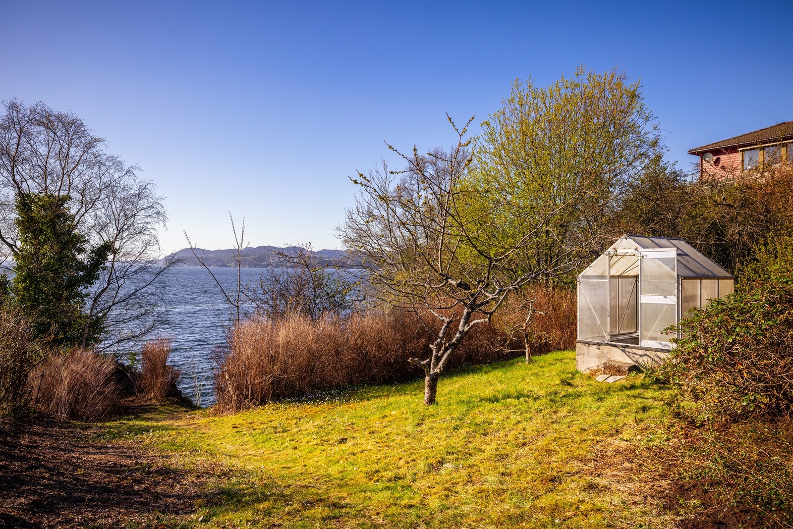 I den nedre delen av hagen er det et koselig lite drivhus med støpt gulv. Galleribilde