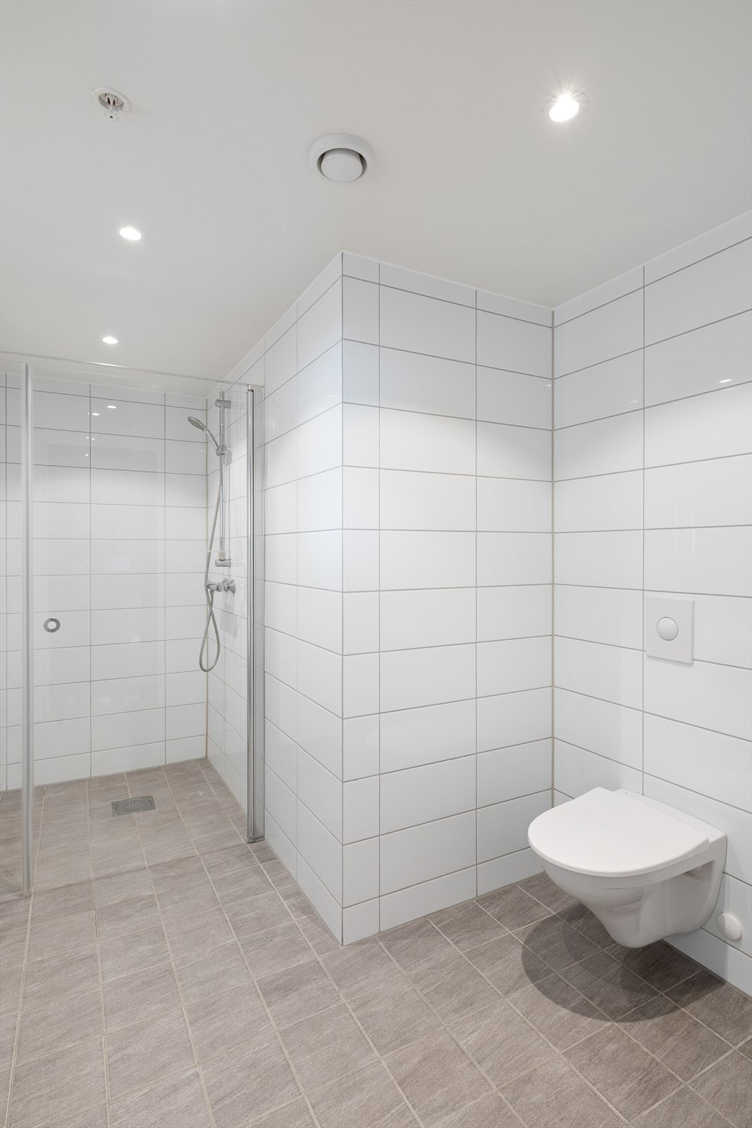 Badet er innredet med seksjon med hel servant, vegghengt toalett med skjult sisterne og glassvegg i dusj. Galleribilde