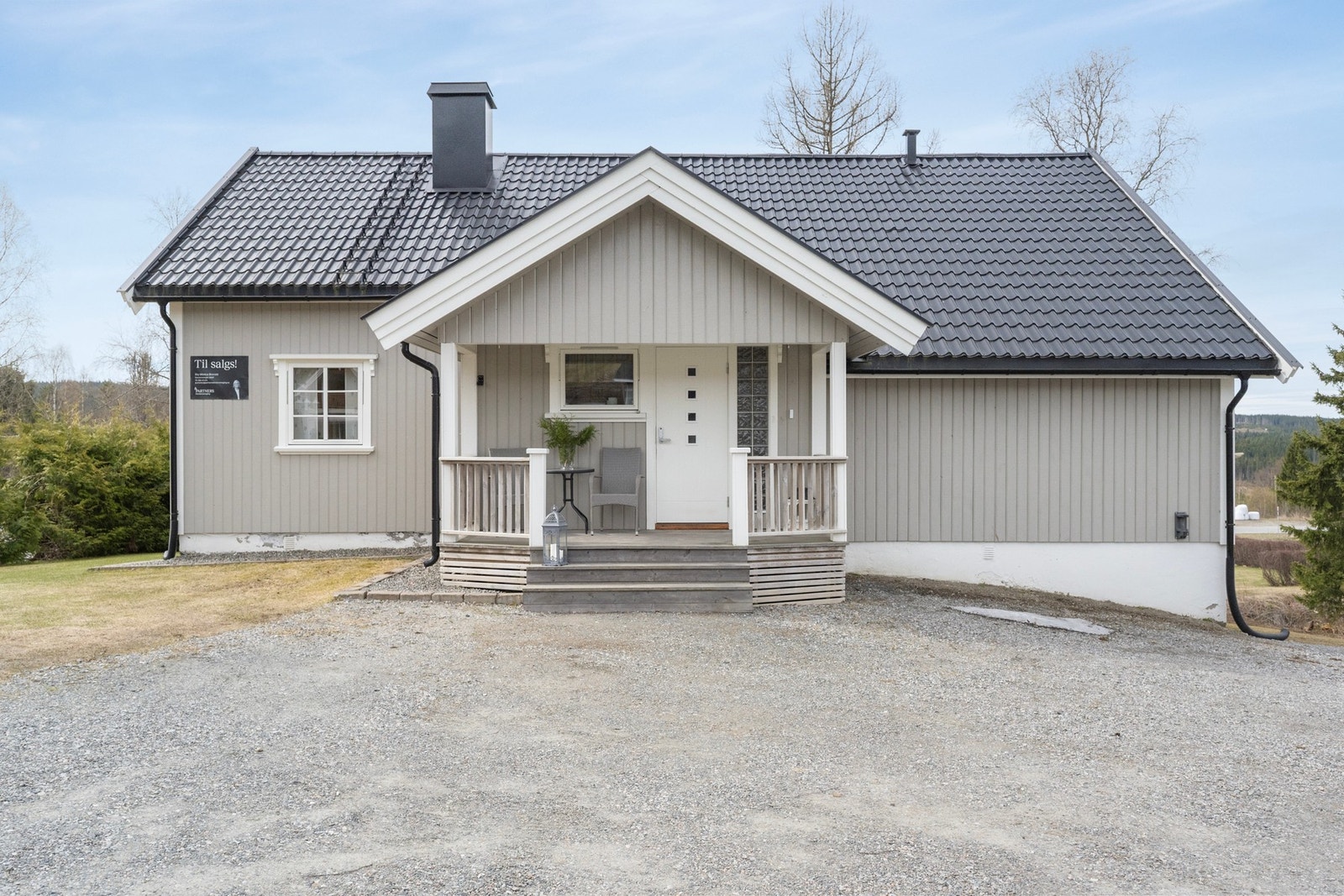 Inngangsparti med trapp og overbygd veranda gir et innbydende førsteinntrykk av eiendommen. Galleribilde