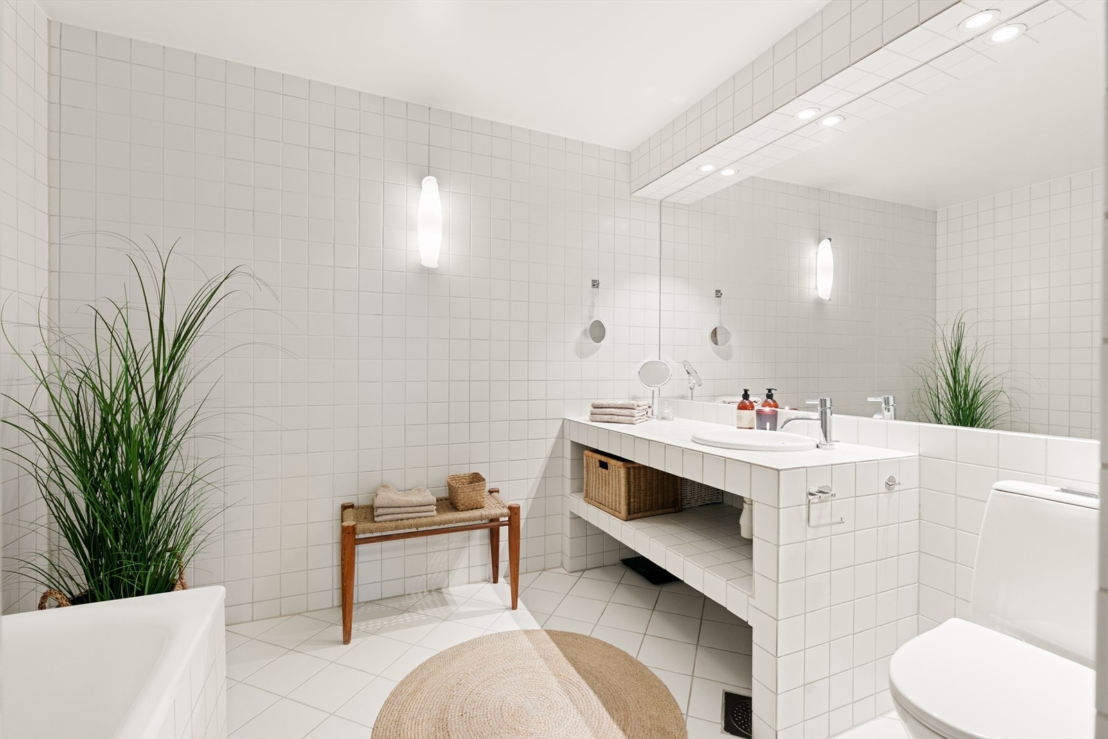 Det andre badet er flislagt og har varmekabler i gulvet. Her er det et innfliset badekar og en servantseksjon med god hylleplass. Galleribilde