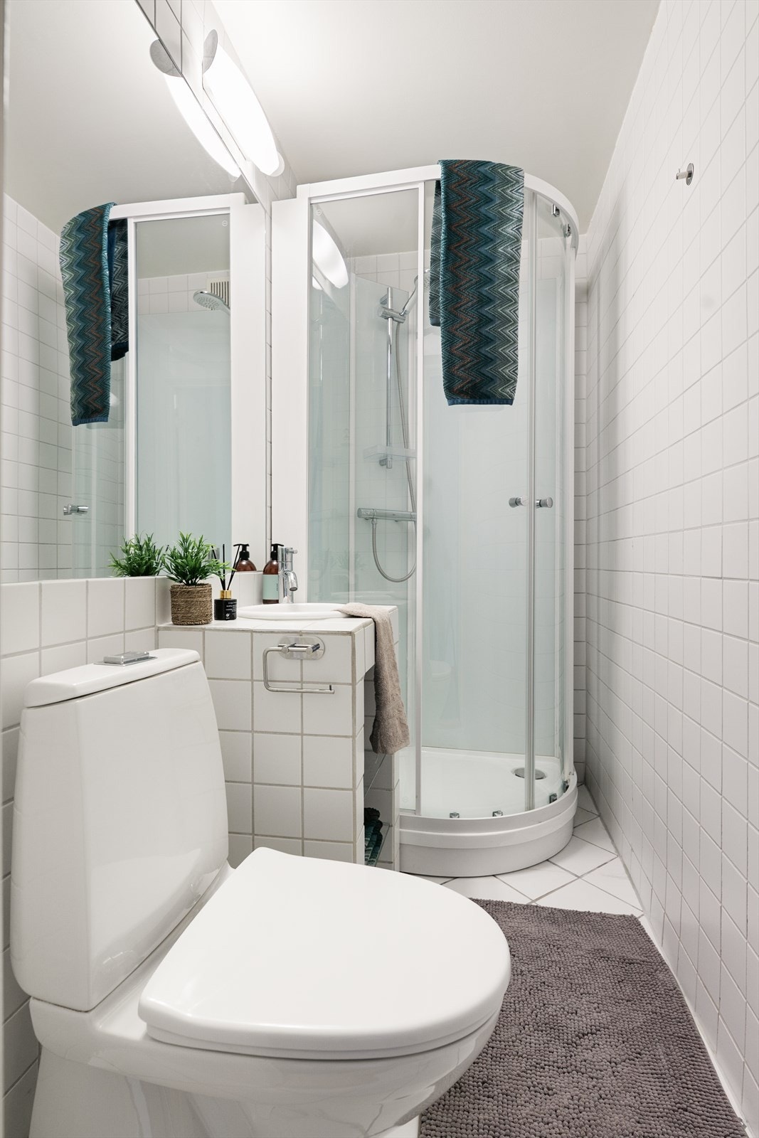 Det ene badet har fliser og varmekabler på gulv, og et dusjkabinett som ble installert i 2022. Galleribilde