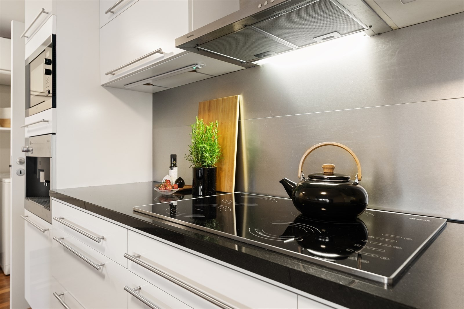 Benkeplaten i kvarts er slitesterk og enkel å vedlikeholde. Over kokesonen er det en børstet stålplate og ventilator med kullfilter. Galleribilde