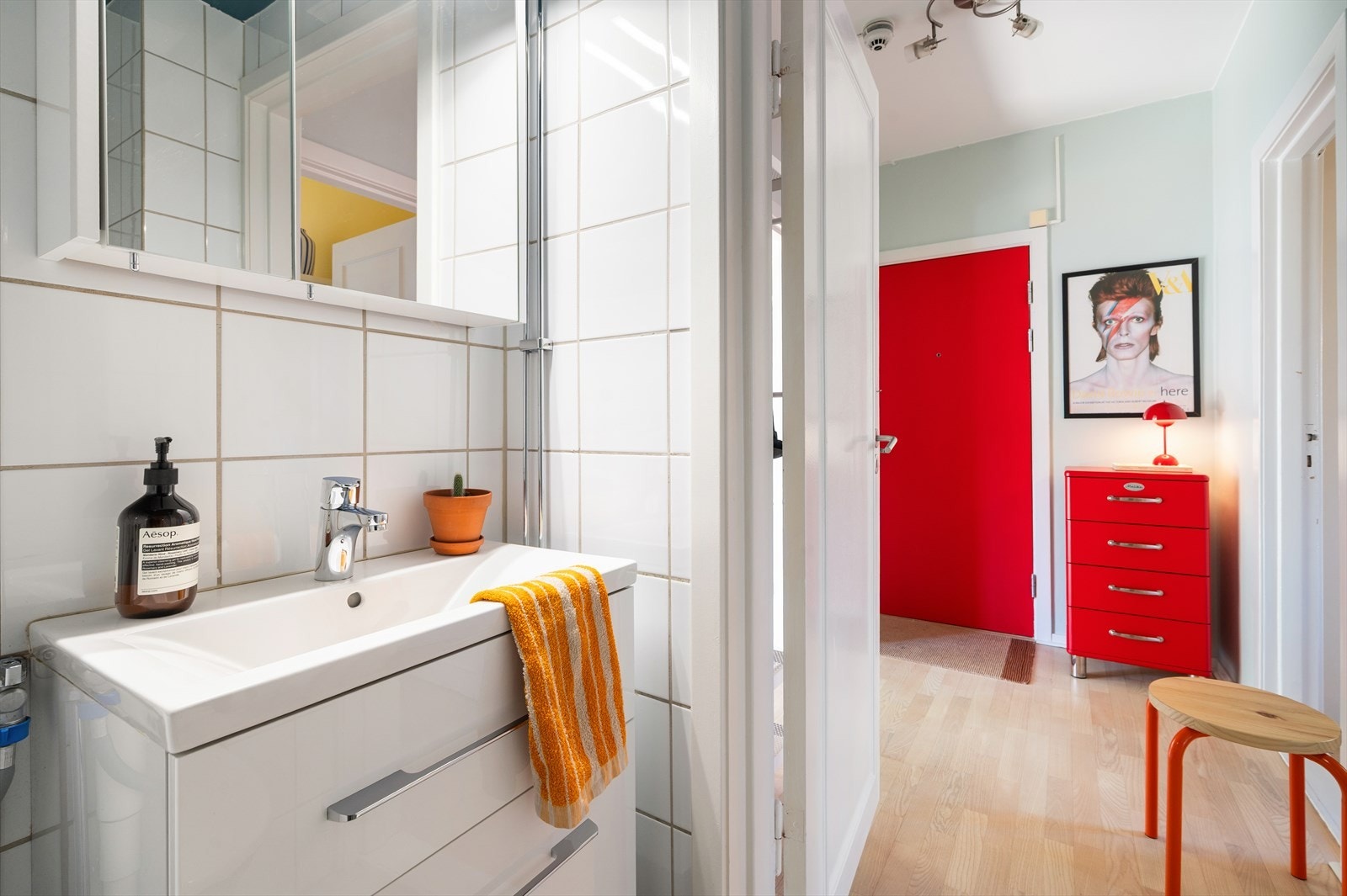 Badet er innredet med gulvstående toalett, dusj direkte på gulv med vegghengte dusjdører i glass, samt servant med praktisk skuffeinnredning under. Galleribilde