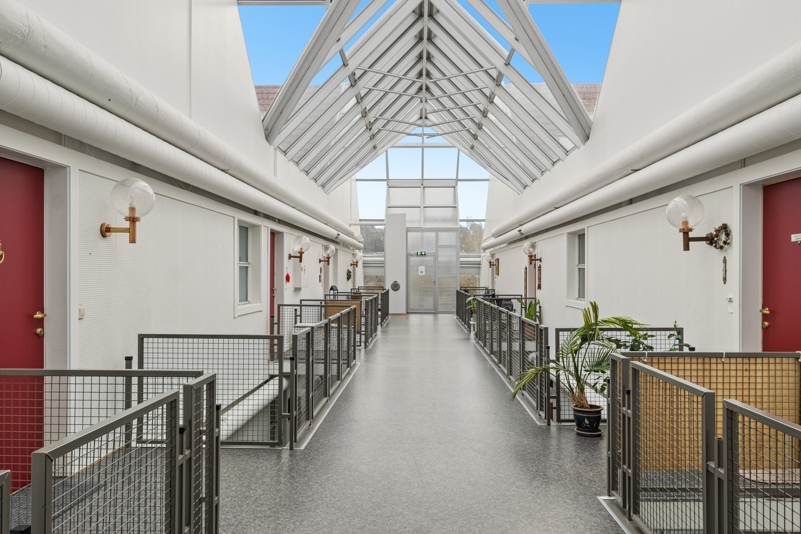 Leiligheten ligger i et bygg med en lys og innbydende fellesgang under glasstak. Galleribilde