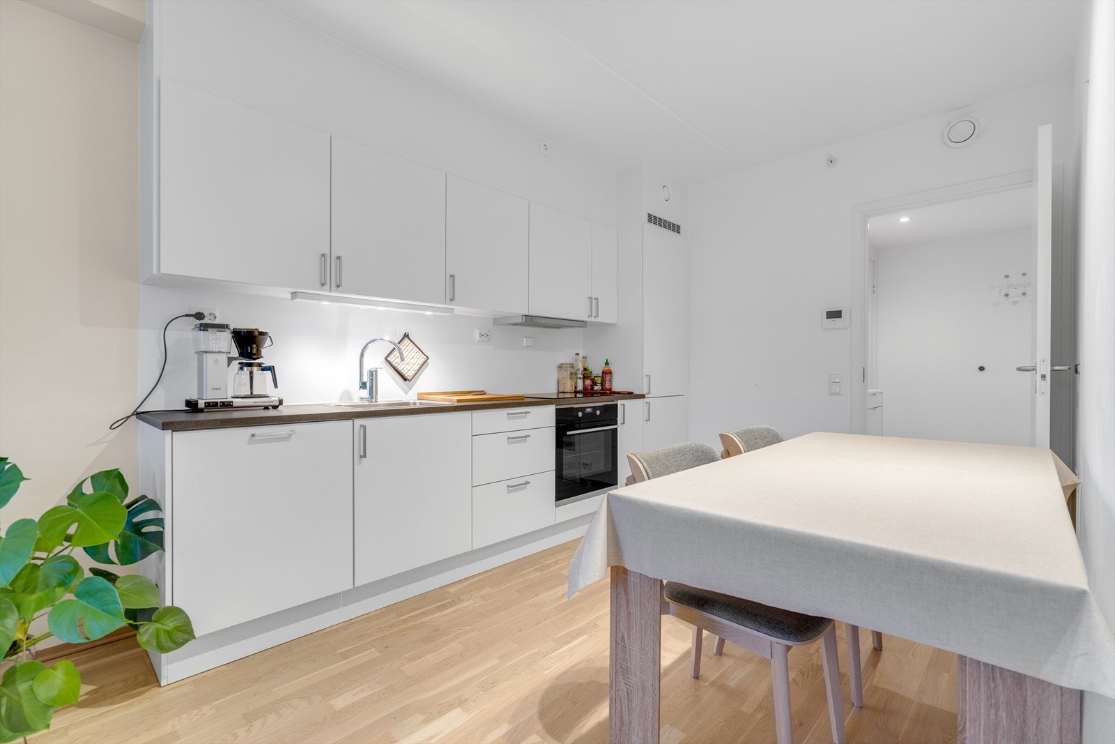 Den åpne løsningen gir en sosial sone med plass til både spisebord og sofagruppe. Galleribilde