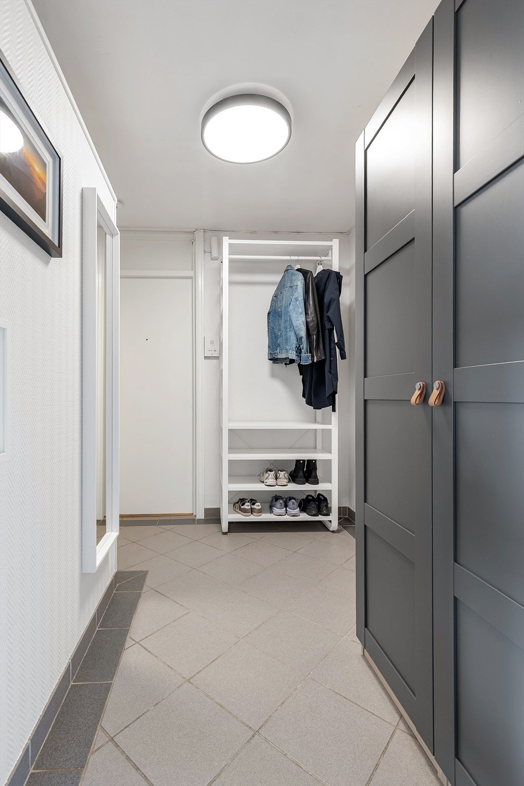 Entréen har flislagt gulv og god plass til oppbevaring av yttertøy og sko. Galleribilde