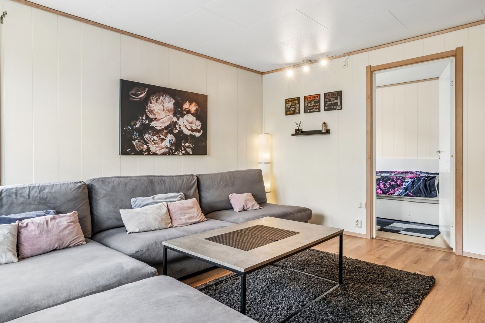 En fin planløsning som gir naturlige soner for plassering av sofa, stuebord, tv- og benk. Galleribilde