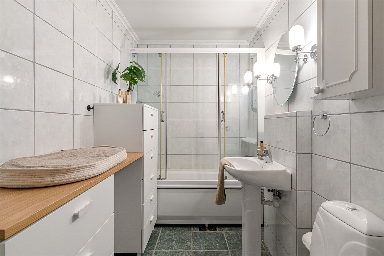 Badet i andre etasje er fra byggeåret og har flislagte overflater, badekar, toalett og søylevask. Galleribilde
