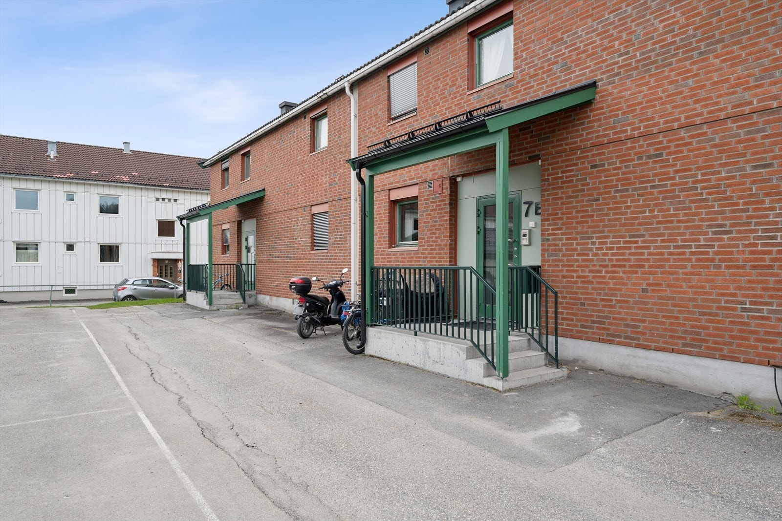 Parkering på borettslagets fellesareal. Nærmeste busstopp, Hønen allé, er kun to minutter unna. Galleribilde