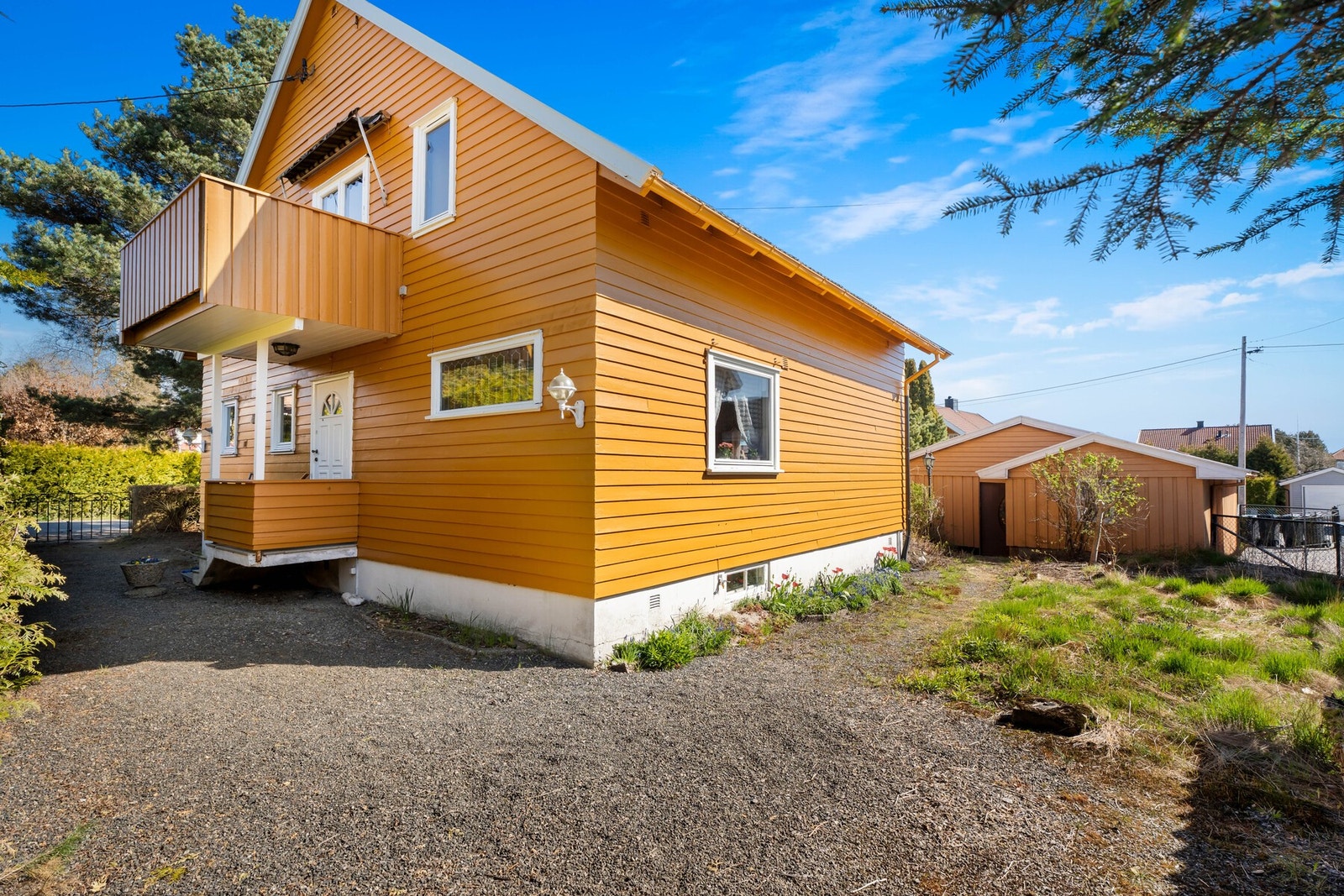 Hagen rammes fint inn av en hekk og et gjerde, og fra veien er det port inn til et gruslagt gårdsrom ved inngangen. Galleribilde