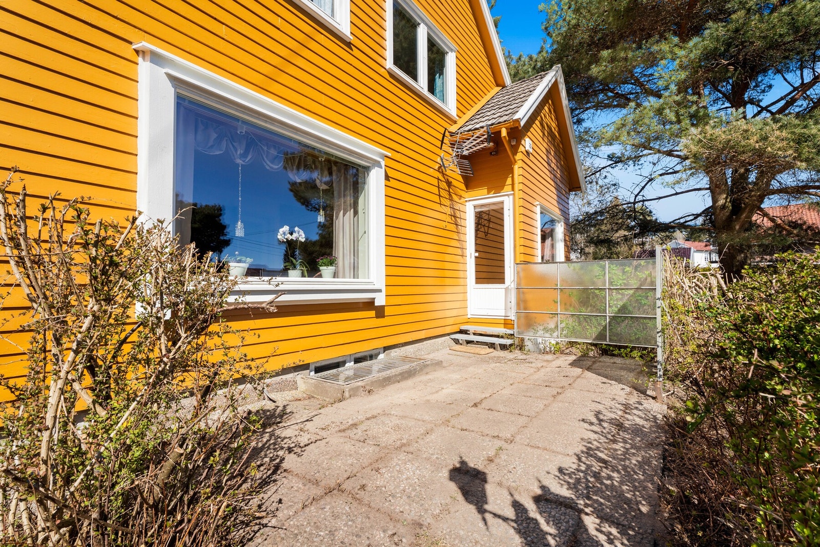 Fra spisestuen er det utgang til en uteplass med levegg, steinheller og trapp til hagen. Galleribilde