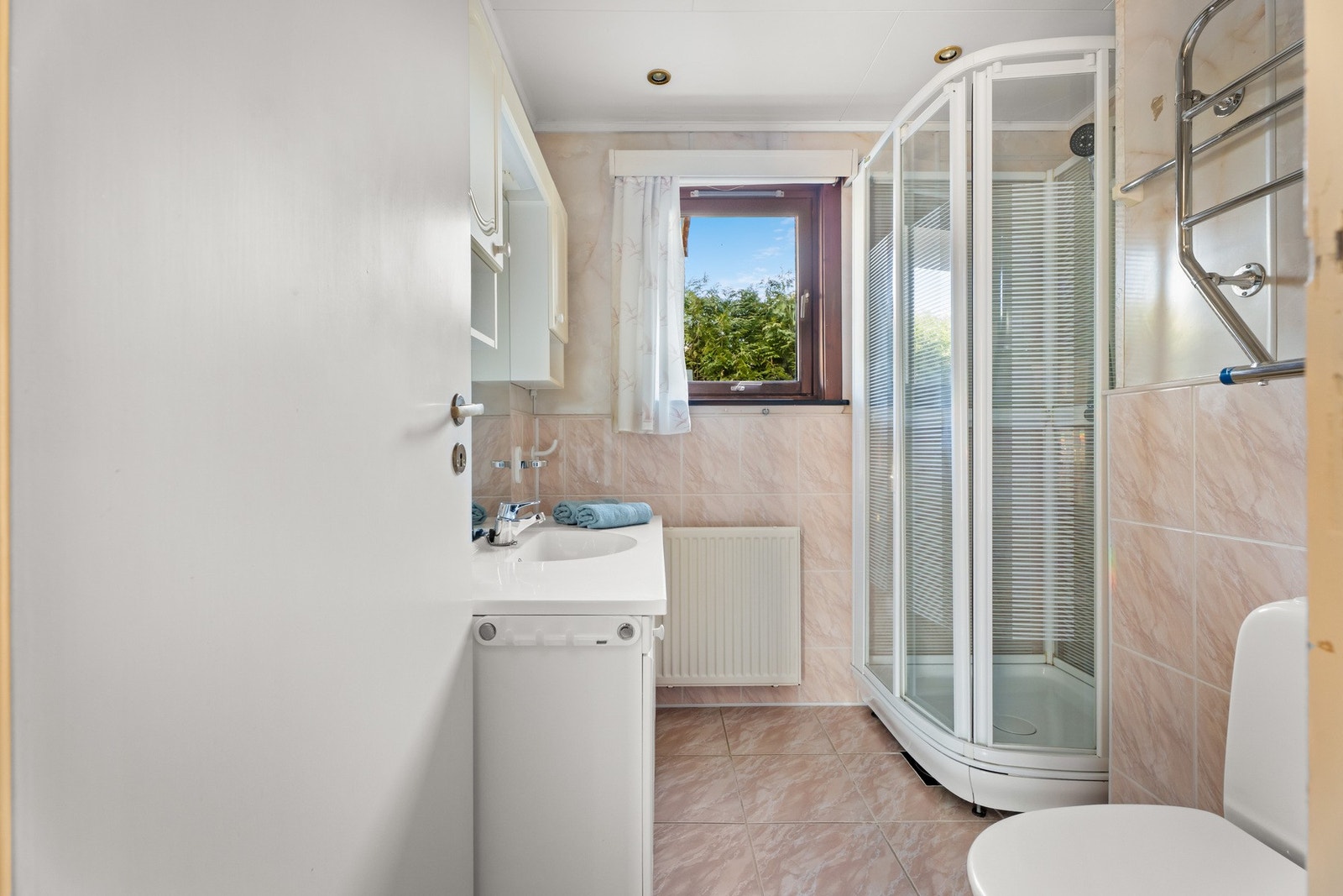 Badet er innredet med downlights, gulvfliser og våtromsplater i flismønster. Galleribilde
