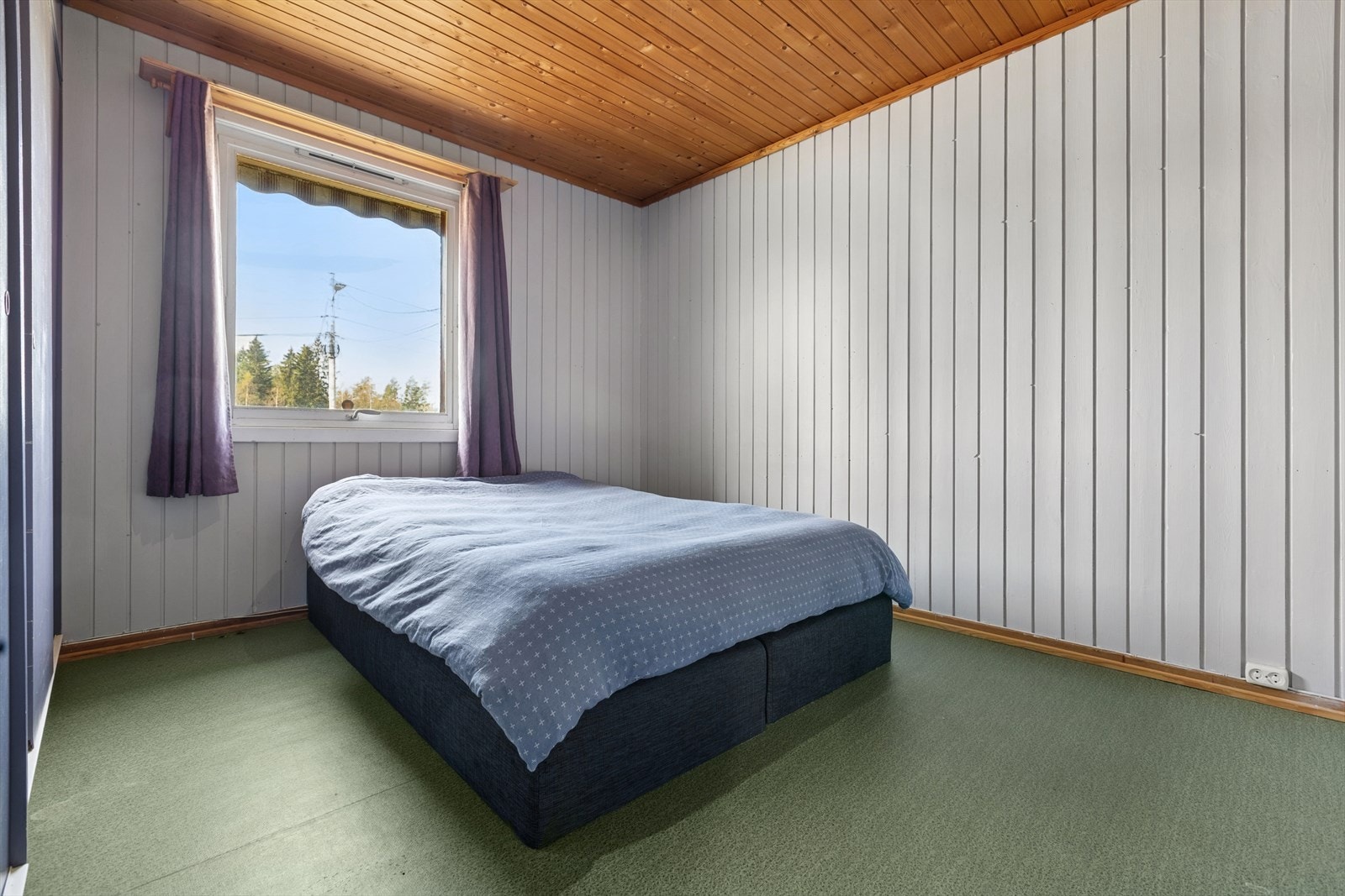 Romslig soverom som har plass til dobbeltseng og annen innredning. Galleribilde