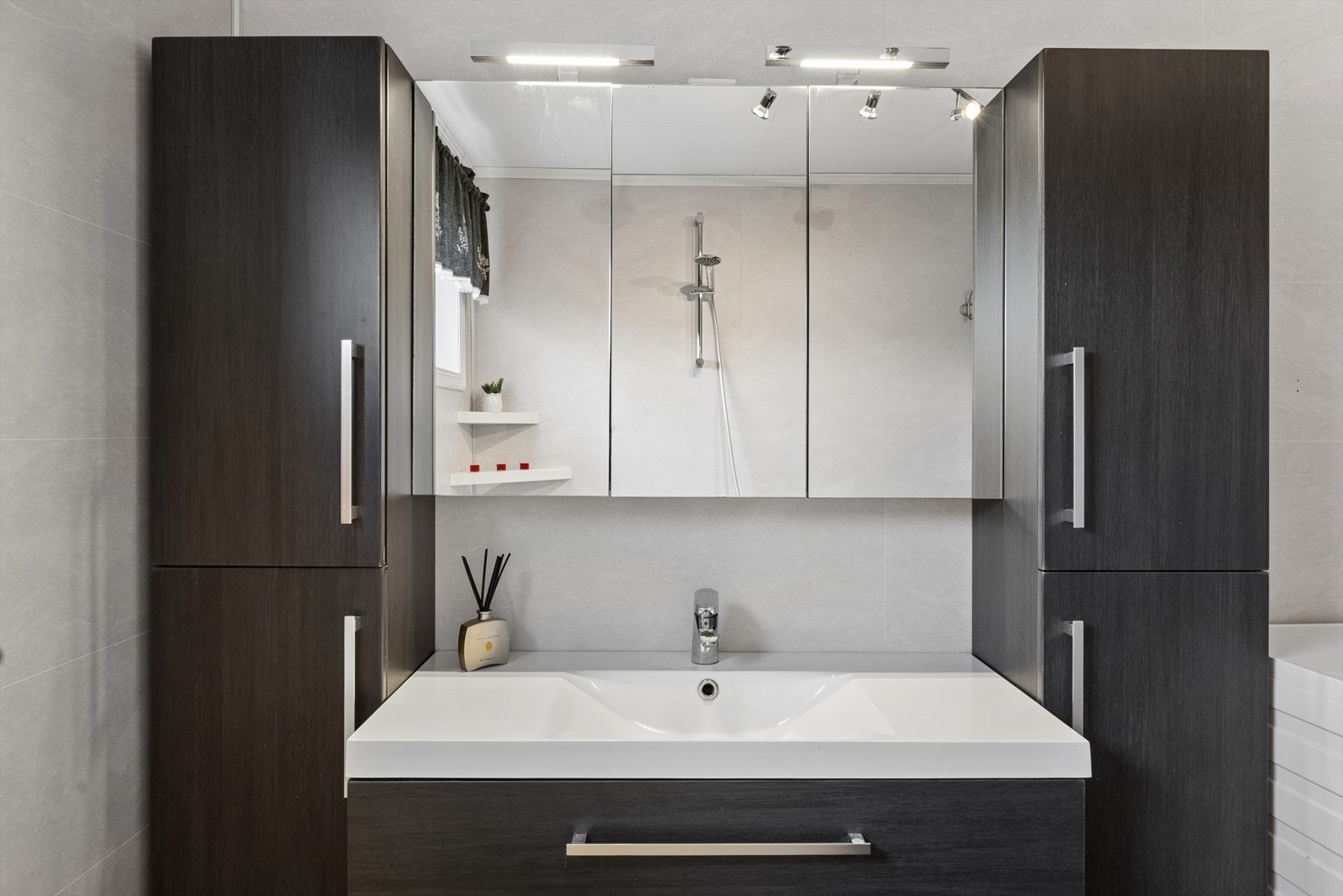 Innredningen på badet har en mørk og moderne flate som har godt med oppbevaringsplass. Galleribilde