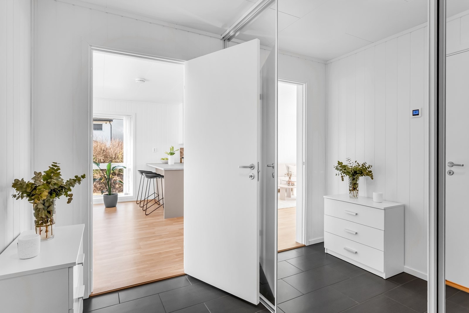 Trivelig entré med flislagt gulv med varmekabler. Her er det god plass for oppbevaring av yttertøy og sko i skyvedørsgarderobe med speilfronter. Galleribilde