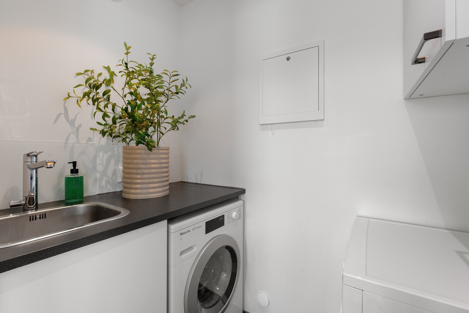 Fra kjøkkenet kommer vi inn til et nyoppusset vaskerom fra 2020 med integrert vask, opplegg for vaskemaskin og rikelig med benkeplass for praktisk bruk i hverdagen. Galleribilde