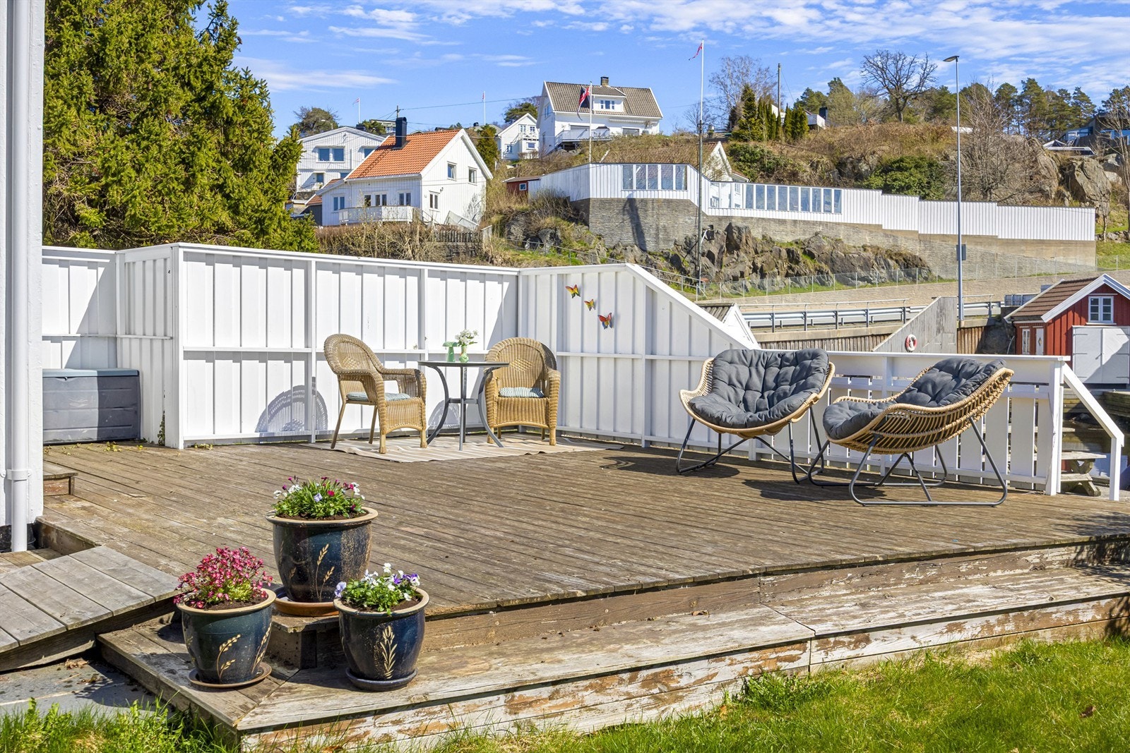 Boligen har terrasse på bakkeplan med direkte utgang fra stuen og takterrasse over tilbygg. Galleribilde