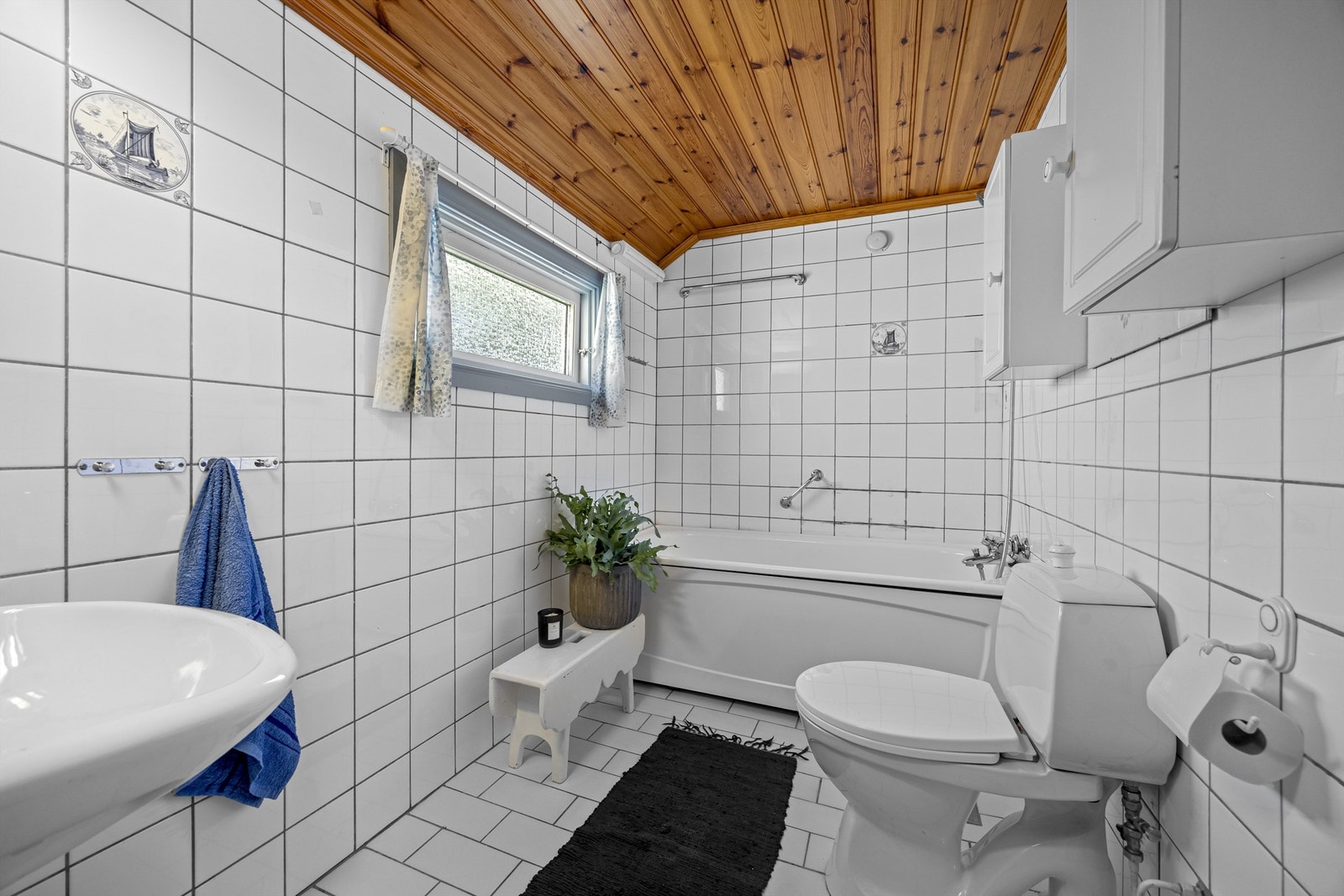 Badet i første etasje er fra 1985/86 og har flislagt gulv med gulvvarme, flislagte vegger og badekar. Galleribilde