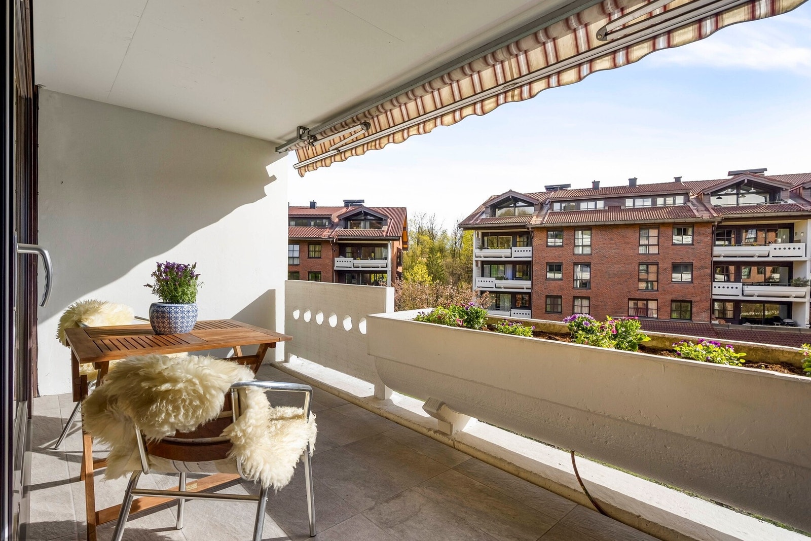 Balkongen er overbygget og utstyrt med markise, slik at stuen skjermes for direkte sol og holdes sval om sommeren når solen står høyest på himmelen. Galleribilde